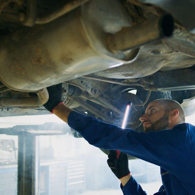 tech looking under car near gas tank tech looking under car near gas tank