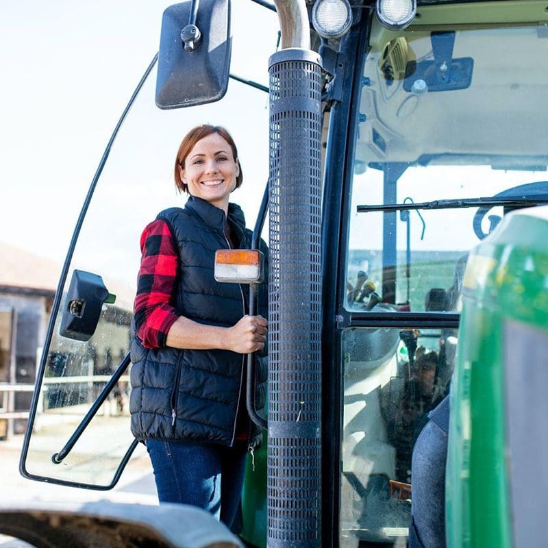 woman getting in green tractor