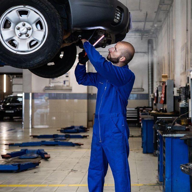 tech looking under car to fix issues tech looking under car to fix issues