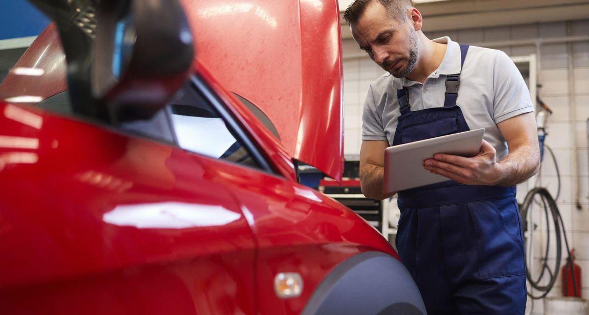 tech working on red suv