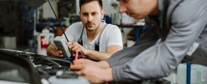 mechanic and tech working on car