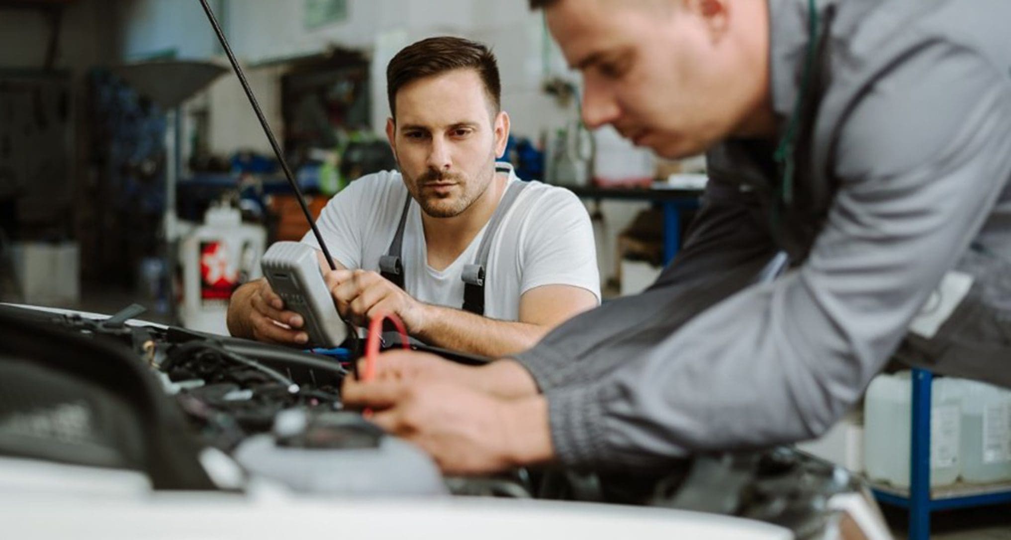 mechanic and tech working on car