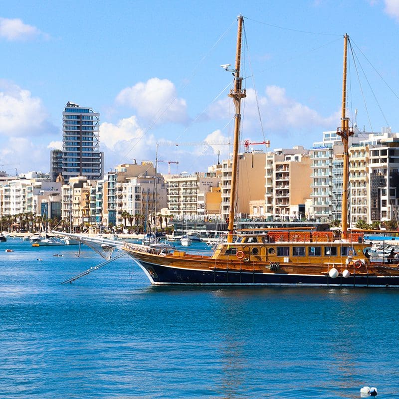 yacht sailing through busy city