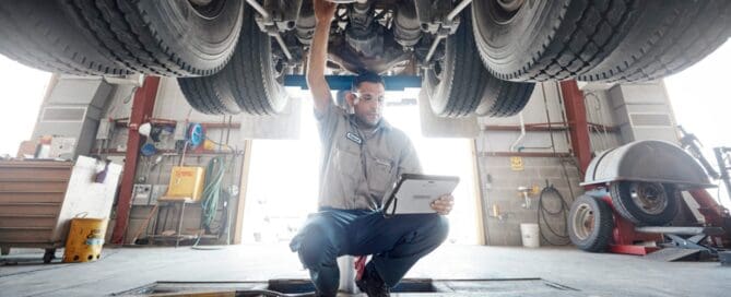 Mechanic under a car looking for problem
