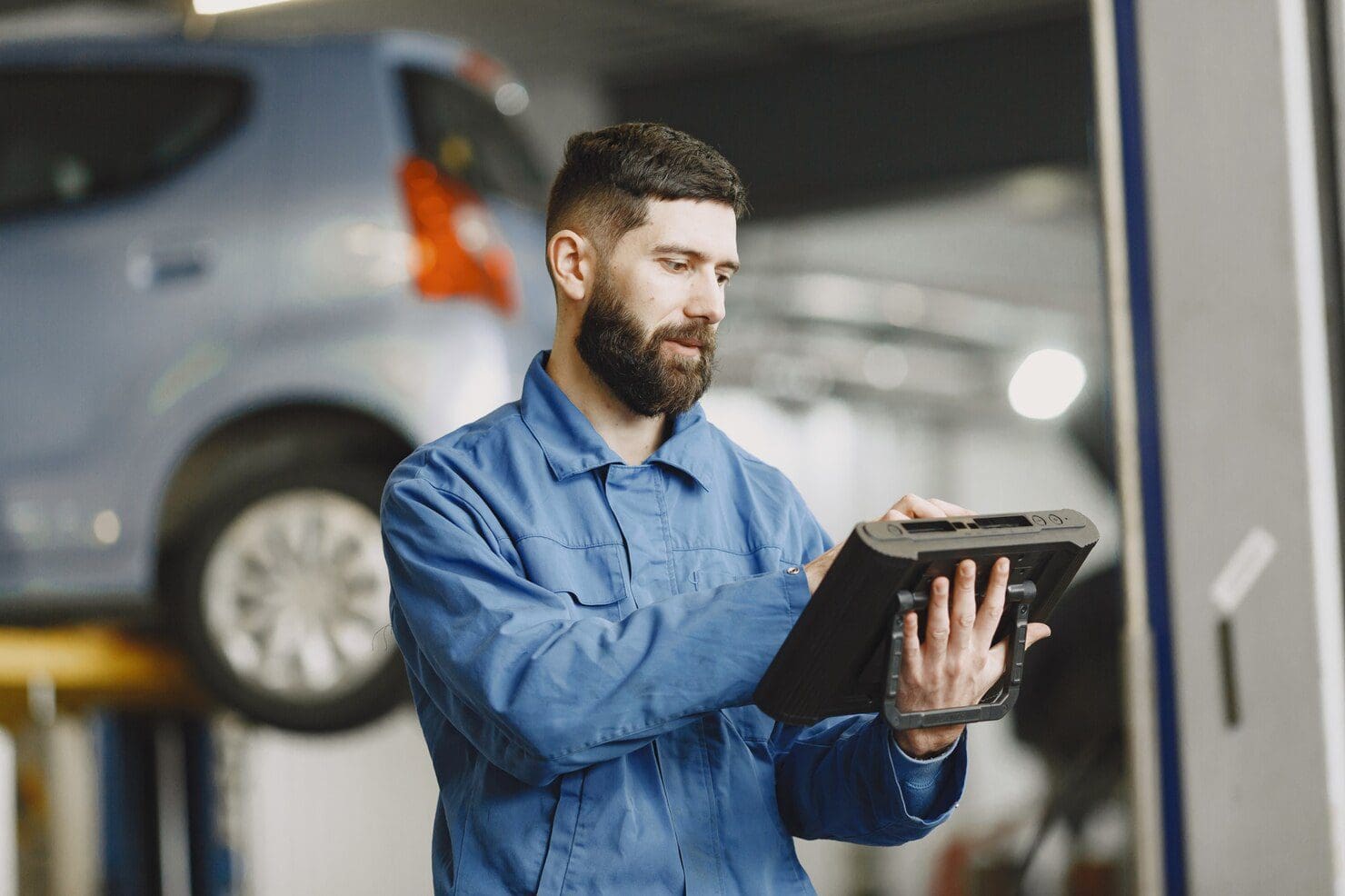 auto tech using reliable vehicle diagnostic tools by triad