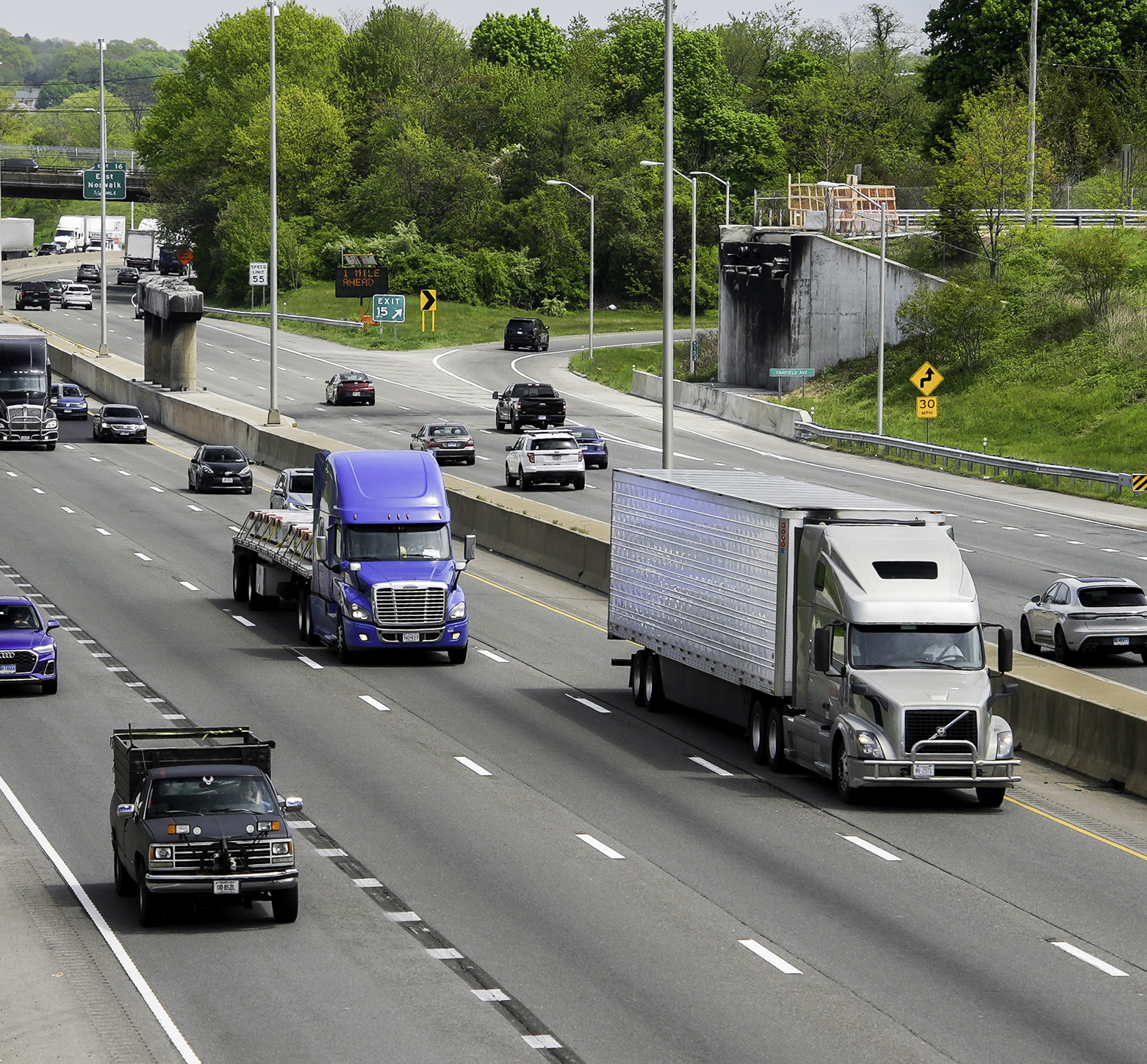 semi trucks on a busy highway with cars