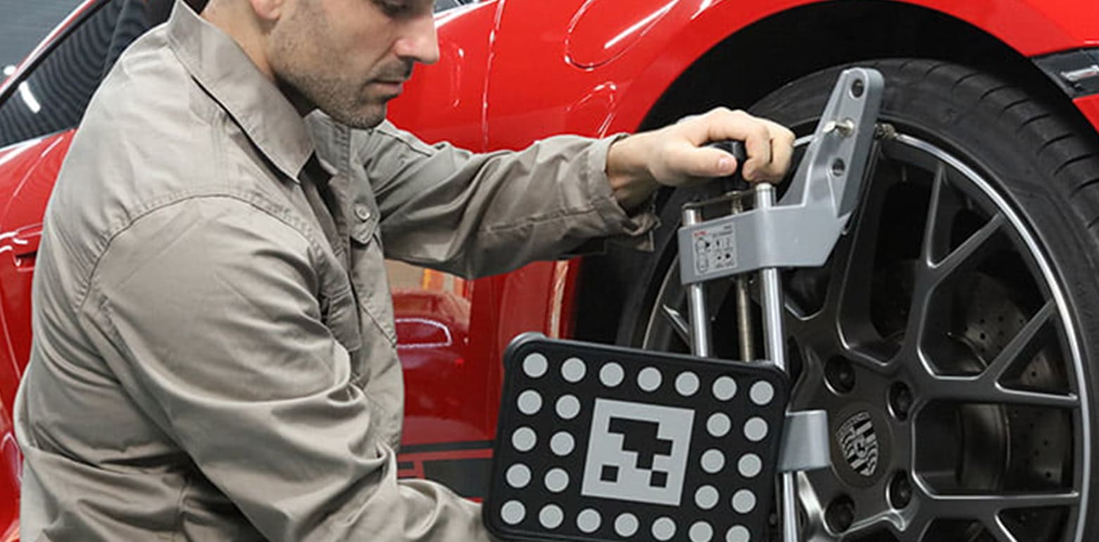 Automobile technician worker doing wheel calibration for adas