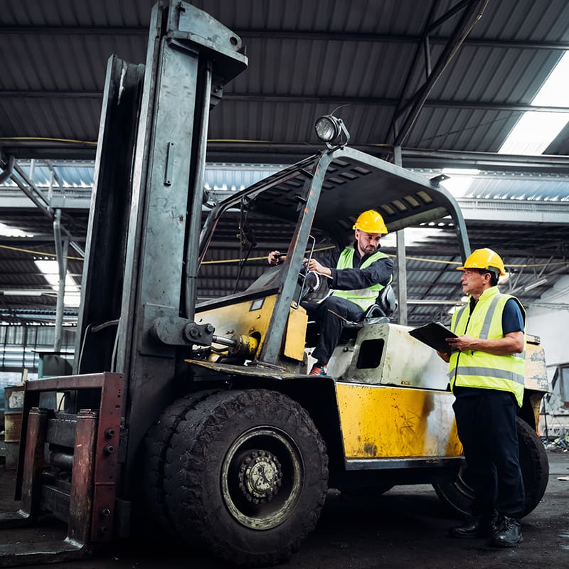 African,American,Technician,Worker,Woman,Use,Laptop,To,Discuss,With techs-working-on-forklift